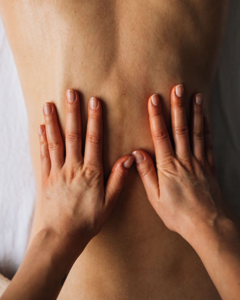 Steady hands working along the lower back
